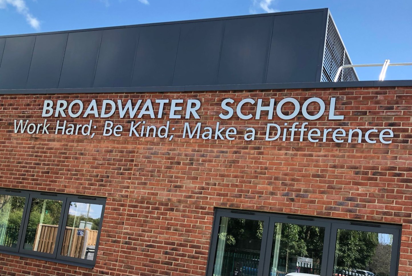 External school wall lettering installed on a brick school building